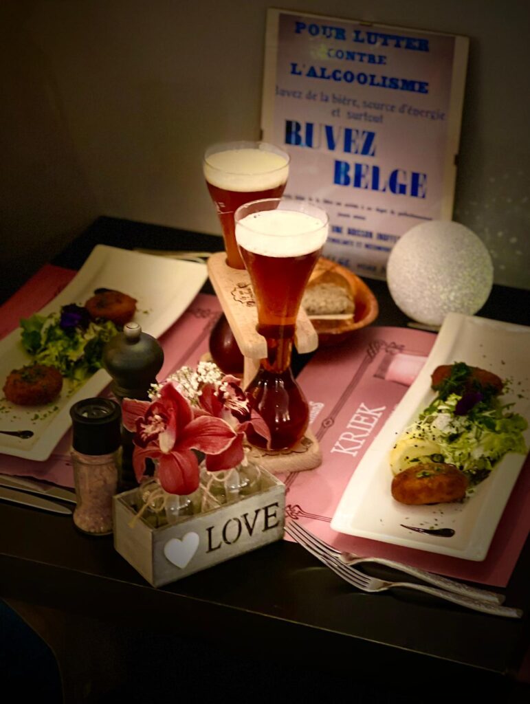 Bières Kriek servies sous l'affiche « Buvez belge »